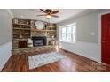 Cozy living room featuring a stone fireplace, bay window, and gleaming hardwood floors at 939 Dameron Rd, Bessemer City, NC 28016