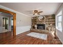 Inviting living room with a stone fireplace, wooden shelves, and hardwood floors at 939 Dameron Rd, Bessemer City, NC 28016