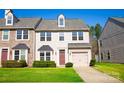 Charming two-story townhome with beige siding, attached garage, and well-manicured front lawn at 9760 Springholm Dr, Charlotte, NC 28278