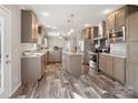 Open kitchen features stainless appliances, gray cabinetry, island with granite countertop, and hard surface floors at 1005 Maywood St, Kannapolis, NC 28081