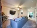 Bright living room with a ceiling fan, a grey couch and an open view to the dining room at 1113 Eastwood Dr, Wingate, NC 28174