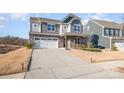 Two-story home featuring stone accents, a white garage door, and a long driveway at 11715 Bryton Pkwy # 2-103, Huntersville, NC 28078