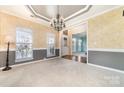 Dining room showcasing decorative wallpaper, a chandelier, and views into the front entry at 1245 Periwinkle Dr, Waxhaw, NC 28173