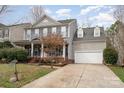 Traditional two-story home featuring gray siding, blue shutters, a landscaped front yard and attached garage at 1245 Periwinkle Dr, Waxhaw, NC 28173