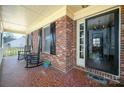 Inviting front porch featuring rocking chairs and classic brick flooring at 126 Lynnwood Ln, Pineville, NC 28134