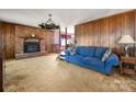 Comfortable living room featuring a brick fireplace, and classic wood paneling at 126 Lynnwood Ln, Pineville, NC 28134