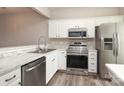 Modern kitchen boasts stainless steel appliances, white cabinetry, and marble countertops at 14713 Lions Pride Ct, Charlotte, NC 28273