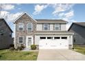 Inviting two-story home with stone facade and a well-manicured lawn under a bright, cloudy sky at 1535 Scarbrough Sw Cir, Concord, NC 28025
