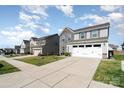 Quiet street view featuring a two-story home with stone accents, a garage, and well-kept lawns at 1535 Scarbrough Sw Cir, Concord, NC 28025