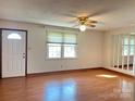 Bright living room features hardwood floors, a ceiling fan, and a big window at 219 W Edison Dr, Statesville, NC 28625