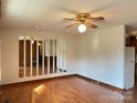 Open-concept living room boasts hardwood floors, a ceiling fan, and unique mirror accents at 219 W Edison Dr, Statesville, NC 28625