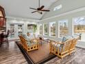 Bright living room boasts vaulted ceilings, wicker furniture, and large windows overlooking the water at 246 Apache Rd, Troutman, NC 28166