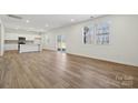 Spacious living room with hardwood floors, stainless steel kitchen appliances, and natural light at 2576 Blue Sky Meadows Dr, Monroe, NC 28110