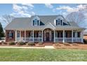 Charming brick two-story home featuring a welcoming front porch and manicured lawn at 286 Canvasback Rd, Mooresville, NC 28117