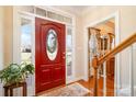 Bright foyer featuring a red front door with oval window, wood floors and staircase at 286 Canvasback Rd, Mooresville, NC 28117