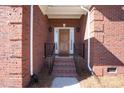 Inviting front entrance with brick steps, a handsome wood door, and stylish black railings and light fixtures at 4008 Saint Andrews Ct, Cramerton, NC 28032