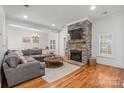 Cozy living space featuring a stone fireplace, hardwood flooring, and stylish furniture for relaxation and comfort at 4008 Saint Andrews Ct, Cramerton, NC 28032
