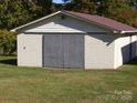 A practical storage building, perfect for hobbies or equipment, surrounded by a grassy lawn at 6434 Miller Rd, Kannapolis, NC 28081