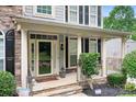 Inviting front porch with stone steps, elegant columns, and a charming, covered entrance with sidelight windows at 7191 Grist Mill Ct, Denver, NC 28037
