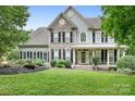 Two-story home featuring stone accents, black shutters, and a beautifully landscaped front lawn at 7191 Grist Mill Ct, Denver, NC 28037