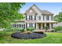 Charming two-story home with stone accents, a welcoming porch, and a beautifully landscaped front yard at 7191 Grist Mill Ct, Denver, NC 28037