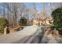 View of a home's driveway leading to the property's exterior with lush surroundings and mature trees at 1006 Lost Cv, Weddington, NC 28104