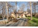 Charming brick and siding home with a bright red front door nestled amongst mature trees at 1006 Lost Cv, Weddington, NC 28104