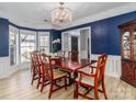 Formal dining room with hardwood floors, a decorative light fixture, and stylish blue accent wall at 12813 Angel Oak Dr, Huntersville, NC 28078