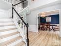 Inviting entryway with staircase and a view into the dining room, which has elegant hardwood floors at 12813 Angel Oak Dr, Huntersville, NC 28078