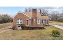 Attractive brick home featuring a cozy front porch and manicured lawn at 1489 Riley St, Albemarle, NC 28001