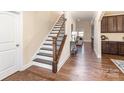 Elegant entryway featuring hardwood floors, a staircase with wooden rails, and neutral paint at 15319 Venezia Ln, Huntersville, NC 28078