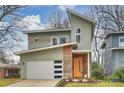 Contemporary two-story home featuring a stylish orange front door, white garage door, and unique architectural details at 3126 Creighton Dr, Charlotte, NC 28205