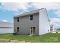 Home back exterior with a large backyard, sliding glass door to the exterior, and gray siding at 3263 Maple Ridge Dr, Gastonia, NC 28052