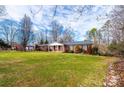 Traditional brick home featuring a covered front porch and lush green lawn at 6000 George Hildebran School Rd, Hickory, NC 28602