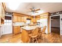 Cozy kitchen with wooden cabinetry, granite countertops, and an island with seating at 6000 George Hildebran School Rd, Hickory, NC 28602