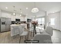 Bright kitchen with stainless steel appliances, quartz countertops, and an open layout to the living area at 6814 Piper Thorn Way, Indian Land, SC 29707
