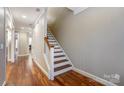 Bright hallway with hardwood floors and staircase leading to the upper level of the home at 7541 Thorn Creek Ln, Tega Cay, SC 29708