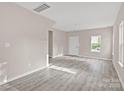 Bright living room with neutral paint, lovely gray floors, and a large window to let the sunshine in at 8705 Moody Rd, Charlotte, NC 28215