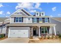 Charming two-story home with stone accents, shingle siding, white garage door, and manicured landscaping at 8720 Acadia Pkwy # 597, Sherrills Ford, NC 28673