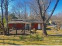 Rear view of a single-story brick home featuring a wooden deck and spacious backyard at 926 Overhill St, Gastonia, NC 28052