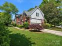 Side view of the beautiful home featuring a lush lawn and basketball hoop by the driveway at 9743 Aegean Ct, Huntersville, NC 28078