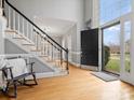 Grand foyer featuring a staircase with black railings and a flood of natural light through large windows at 9743 Aegean Ct, Huntersville, NC 28078