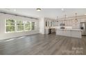 Open-concept kitchen with gray cabinets, stainless steel appliances, and large windows at 1308 Stone Marker Dr, Monroe, NC 28112
