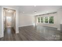 Spacious living room with large windows, gray wood flooring, and neutral paint at 1308 Stone Marker Dr, Monroe, NC 28112