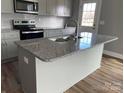 Bright kitchen featuring a granite-topped island with a stainless steel sink and modern faucet at 1530 W Horah St, Salisbury, NC 28144