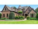 Stunning home with brick and stone exterior, turret, and professional landscaping, creating exceptional curb appeal at 16824 Ashton Oaks Dr, Charlotte, NC 28278