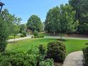 Beautifully landscaped front yard with lush green grass and mature trees in a peaceful neighborhood at 16824 Ashton Oaks Dr, Charlotte, NC 28278
