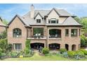 Spacious rear elevation featuring brickwork, large patio area and multiple outdoor seating arrangements at 16824 Ashton Oaks Dr, Charlotte, NC 28278