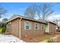 Side view of a brick home featuring multiple windows, a paved driveway, and a tidy landscape at 1780 Lumpkin Cir, Rock Hill, SC 29732