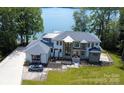 Breathtaking aerial view of a luxurious waterfront home featuring manicured grounds and serene lake views at 180 Willow Point Rd, Troutman, NC 28166